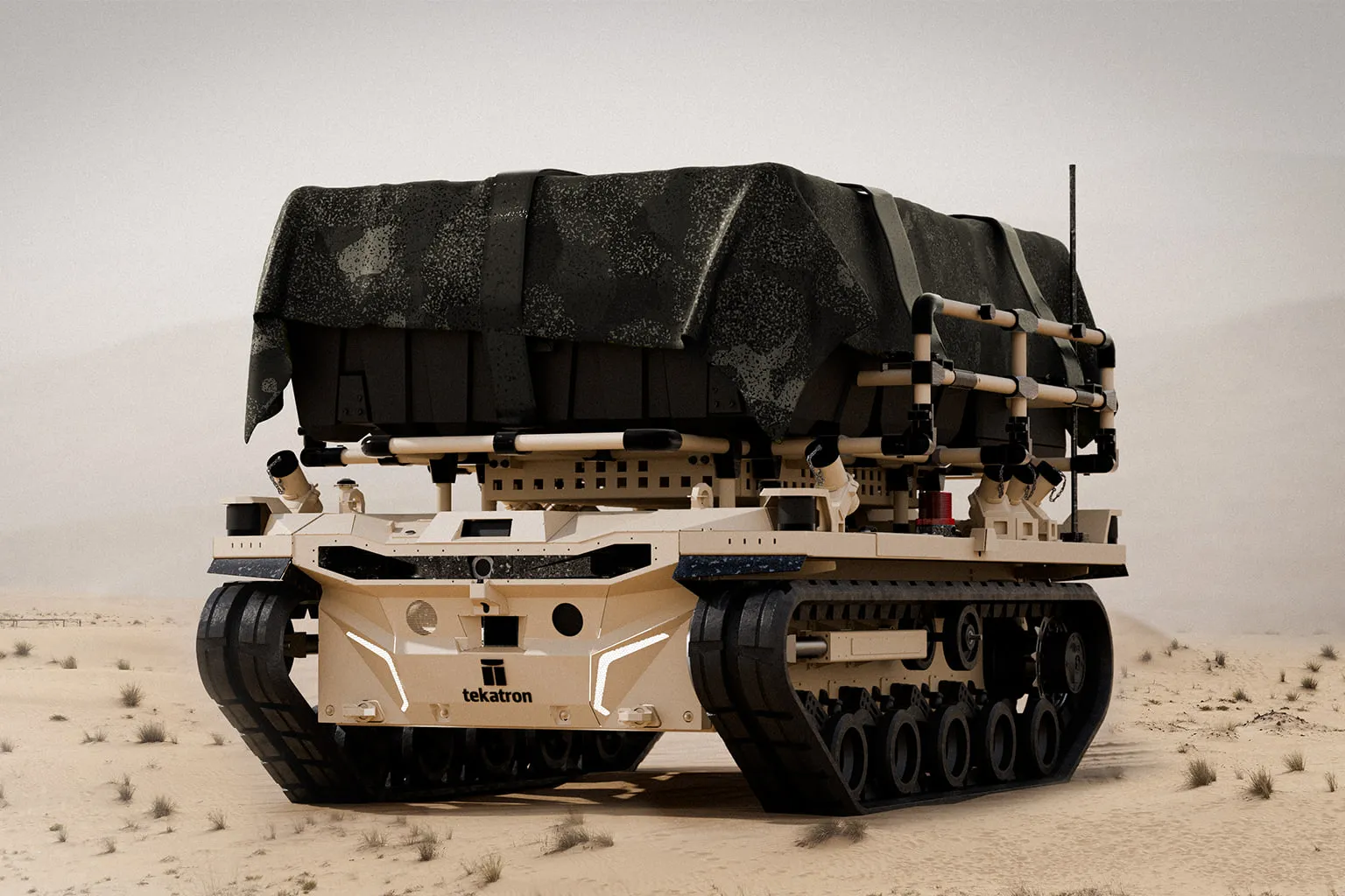 Palem tracked platform in desert terrain carrying a covered logistics load strapped across its full-length deck.