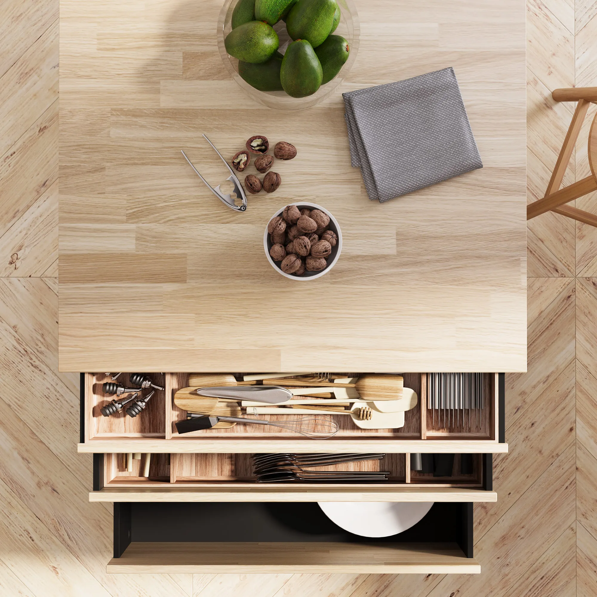 Overhead view of a finger-jointed oak worktop with an open drawer below holding a wooden cutlery insert, and a second deeper drawer of plates.